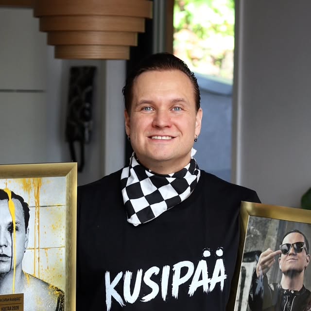 Niko Ailamo (Erakossa) hymyilee ja pitelee kahta kehystettyä kultalevyä, yllään Kusipää-paita.